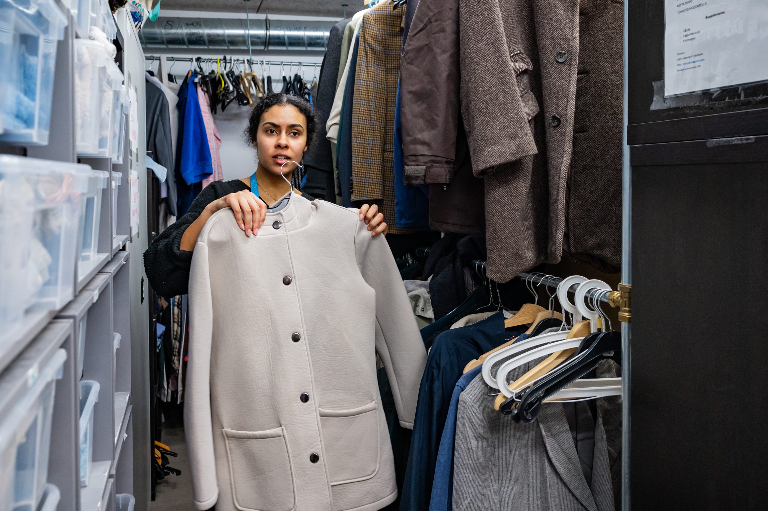 Une bénévole propose un vêtement qui a été donné à une personne sans chez-soi au sein de notre vestiaire solidaire DoucheFLUX