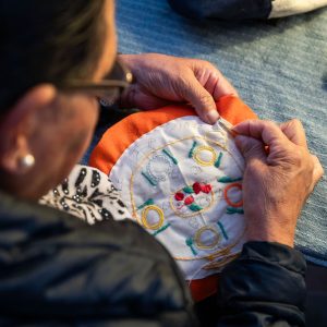 Une personne fait de la broderie à DoucheFLUX