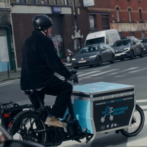 Un bénévole médiathèque volante pédale en rue